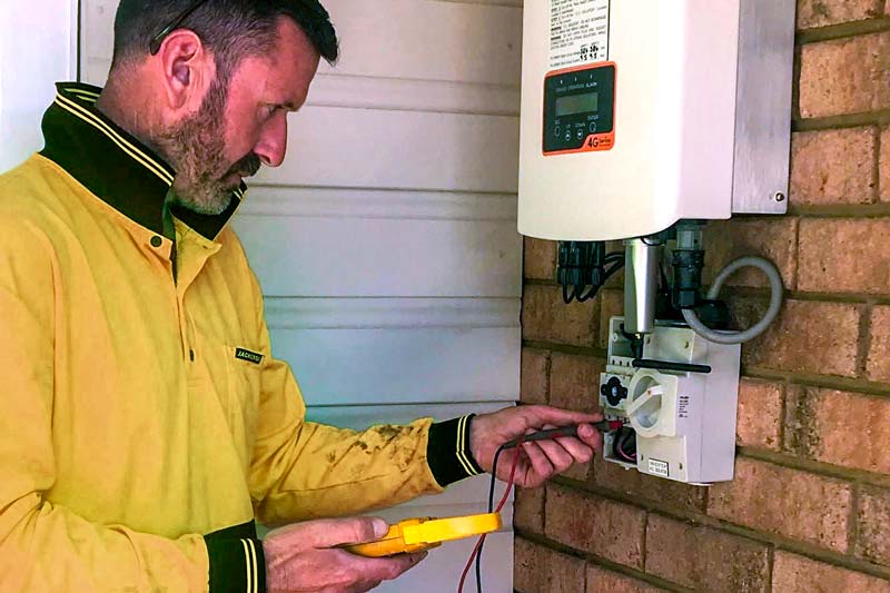 Green Sun Solutions technician testing a solar power unit for faults and correct operation