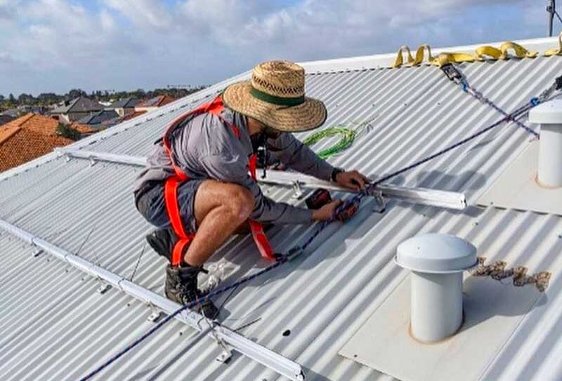 Solar panel rail installation Green Sun Solutions installer fitting solar panel rails on a roof